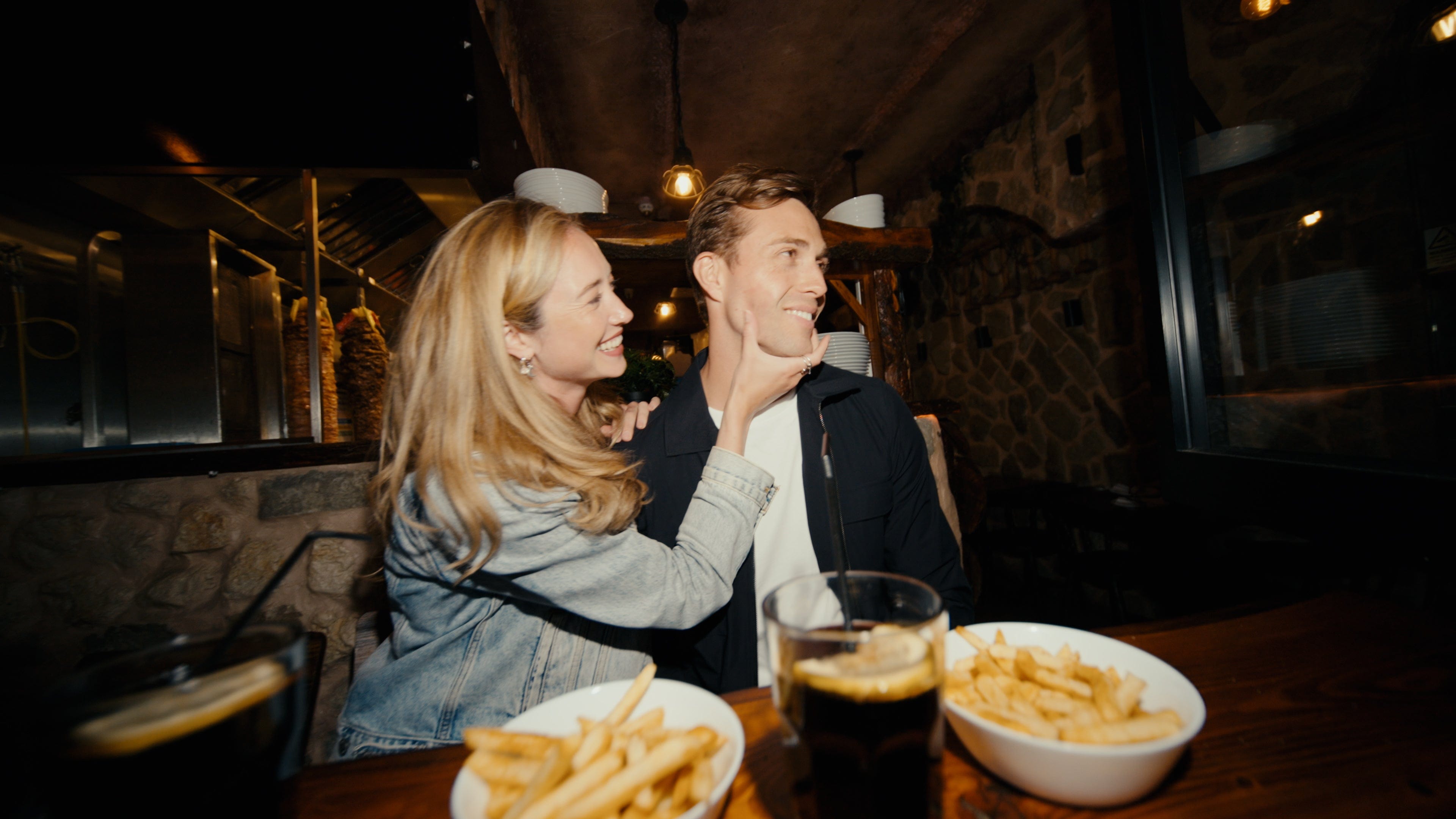 Couple eating chips at a dark restaurant